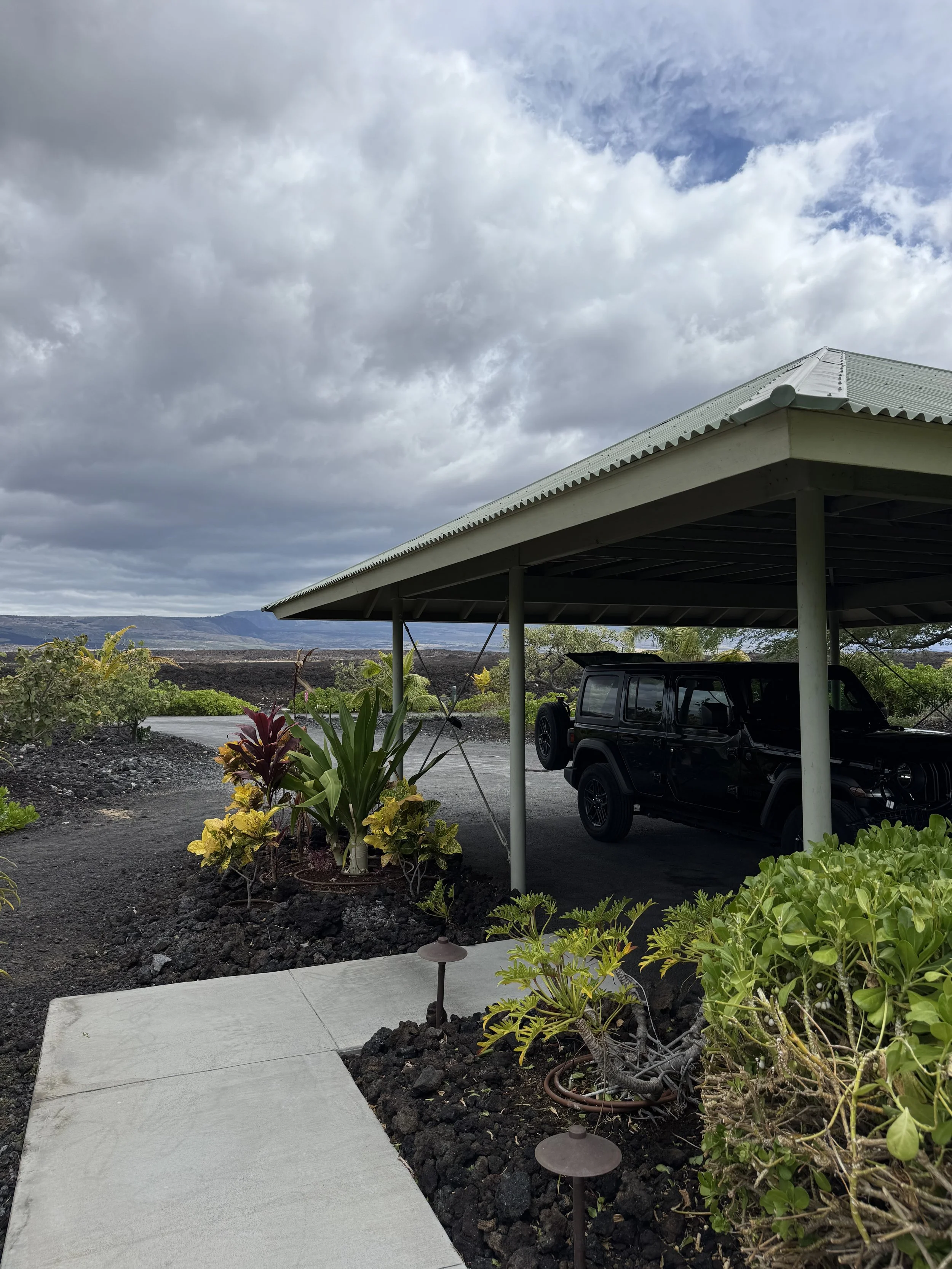 Covered parking beside the cottage garden path
